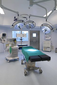 a hospital room with medical equipment and lights on the ceiling, including an operating table