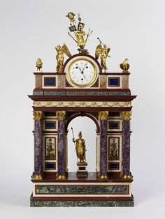 an ornate clock with statues on top of it