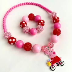 Includes Necklace and Bracelet  Necklace and bracelet are made with Stretch Magic Elastic. No need for clasps! Peppa Pig Pendant made of PVC Pink and red 20mm chunky beads  Please message me if you would like it made longer or shorter. I can add or remove a bead. Perfect for a photo prop or dress up! 👗  Recommend Ages: 3 and up Please supervise children with small parts Fun Red Round Jewelry, Playful Pink Jewelry With Large Beads, Playful Red Adjustable Necklace, Playful Red Nickel-free Jewelry, Red Plastic Beaded Bracelets As Gift, Fun Red Adjustable Necklace, Plastic Bead Jewelry For Birthday, Fun Red Plastic Jewelry, Playful Red Jewelry For Valentine's Day