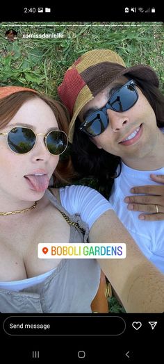 two women laying in the grass with their tongue out