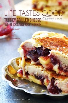 a panini sandwich is stacked on a plate with cranberry sauce in the background