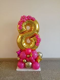 the number six is made out of gold and pink balloons with stars on them, as well as other decorations