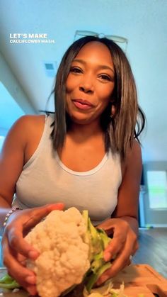 a woman holding a piece of cauliflower in her hands