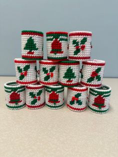 a stack of knitted christmas bracelets sitting on top of a table