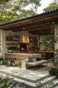 an outdoor kitchen and living area with stone walls