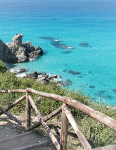 stairs lead down to the beach with clear blue water