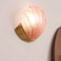 a wall light that is on the side of a wall next to a wooden clock