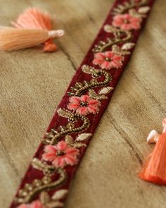 Simple and elegant, dressy yet subtle. Here's a pretty trim with a floral design created with pink and beige embroidery on a maroon / deep red cotton fabric. Embellished with sequins and beads in old gold, that gives the trim a very old world look. Use it to embellish your denim jackets, or border your sarees. Or create home décor like lamps or curtain ties. Or accessories like hair bands. One trim, countless possibilities. Price for 1 mtr Note - Colours may look slightly different to you from w Diwali Floral Embroidery Choli In Chinon, Festive Resham Embroidered Long Lehenga, Festive Dola Silk Choli With Embroidered Border, Designer Red Anarkali Set With Embroidered Border, Red Chanderi Anarkali Set With Floral Embroidery, Red Anarkali Set With Embroidered Border For Designer Occasions, Party Sharara With Embroidered Border In Chanderi, Long Lehenga With Zari Work For Festive Occasion, Festive Floral Embroidery Silk Choli