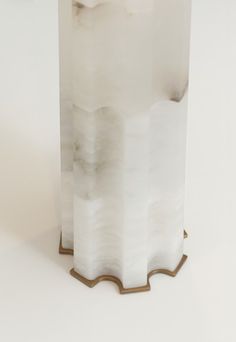 a tall white vase sitting on top of a table