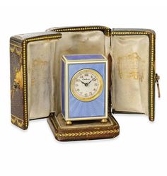 an open book with a clock in it on a white background, the cover is blue and has gold trimmings