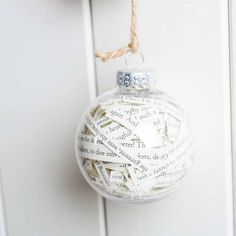 a white ornament hanging from a door with words written on it and twine