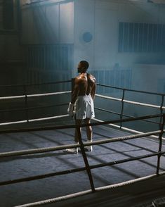 a man standing in the middle of a boxing ring