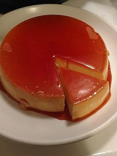 a piece of cheesecake on a white plate with caramel sauce and a slice cut out