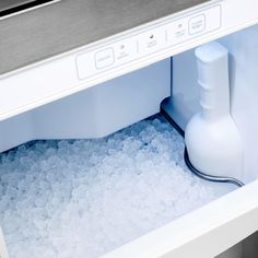 an ice chest with water in it and a bottle on the bottom, next to some ice