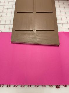 a piece of chocolate is sitting on top of a pink mat