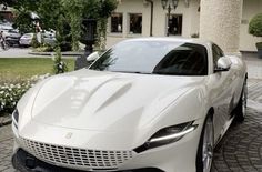 a white sports car parked in front of a building