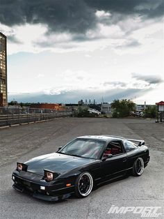 a black car parked on top of a parking lot