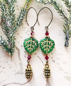 Festive Pine Cone Earrings, Christmas Forest Earrings, Yule Leaf Earrings, Forest Earrings, Dryad Earrings  These festive green leaf and pine cone earrings are so rustic and beautiful! Wear them when you go wandering in the winter woods to gaze at the winter magic. I made the earrings with: *detailed gold-tone pine cone charms *lovely green Czech glass leaf beads with gold etching *antiqued gold Tierra Cast bead caps *red Swarovski crystals *antiqued brass leaf-shaped ear hooks with little rubbe Festive Green Dangling Beads Earrings, Pine Come Earrings, Real Pinecone Earrings, Green Dangle Christmas Jewelry, Indian Inspired Jewelry, Handmade Green Leaf-shaped Earrings, Woodland Earrings, Christmas Forest, Mermaid Bracelet