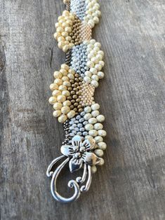 "I wanted to create some pieces that reflected how I feel about Snow, holidays and Winter. This is a custom, original design by Sonserae Designs. I love choosing the colors first...All the things that remind me of transitioning to Winter and the Holidays. All the beads are high quality Japanese Glass beads of various sizes. It's a great, unique gift for the holidays or any special occasion...hand beaded by me with love and care. I'm also able to make it in different colors if you prefer. I hope Handmade Gold Beaded Bracelets As Gifts, Handmade Gold Beaded Bracelets For Gifts, Artisan Silver Beaded Bracelets With Unique Variations, Handmade Fusion Bracelet With Round Beads, Fusion Style Handmade Beaded Bracelets With Round Beads, Handmade Silver Bracelets For Gift, Handmade Cream Bracelet Jewelry, Handmade Cream Pearl Bracelet Gift, Handmade Cream Bracelet