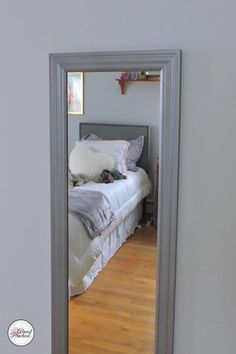 a mirror reflecting a bed in a bedroom