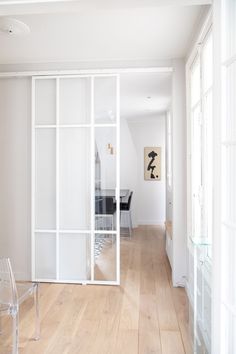 an empty room with white walls and wooden flooring is seen through the glass doors