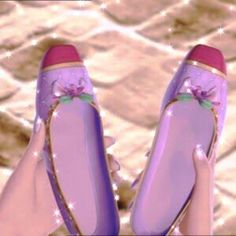 a pair of purple shoes with pink bows on the toes are being held by someone's hand