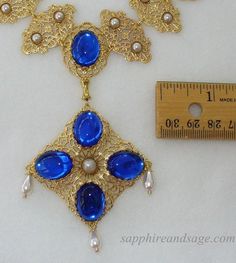 Wear a piece of history with this "Mary, Queen of Scots" movie-inspired reproduction Tudor necklace. Crafted with ornate gold-tone filigrees and captivating acrylic cabochons, this regal accessory adds unique glamor to any look. Necklace length is 17-18", with a 2-3" extender attached. Longer and shorter lengths available upon request, message me with your desired length. Costume Gold Metal Jewelry, Elegant Gold Costume Jewelry, Elegant Gold Jewelry For Costume, Vintage Baroque Jewelry With Historical Design, Vintage Filigree Baroque Necklace, Collectible Ornate Jewelry With Historical Design, Vintage Filigree Baroque Jewelry, Collectible Gold Baroque Jewelry, Ornate Gold Necklace With Cabochon