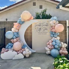 balloon arch with moon and clouds in front of a house for a baby shower or birthday party