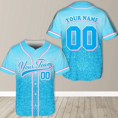 a baseball jersey with the name your team on it in blue and pink glitters