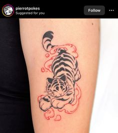 a small tiger tattoo on the right arm and shoulder, it is black and white with red ink