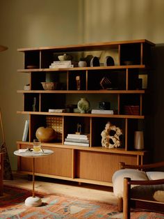 a living room filled with furniture and bookshelves next to a wall mounted clock