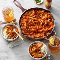 a pan filled with meat and rice next to drinks