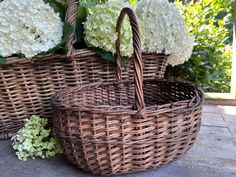 two wicker baskets with white flowers in them