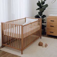 a baby crib in the corner of a room next to a bed and dresser