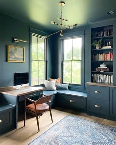 a home office with blue walls and built - in bookshelves