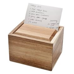 a wooden box with a note and pen in it