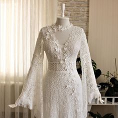 a white dress on a mannequin in front of a brick wall and window