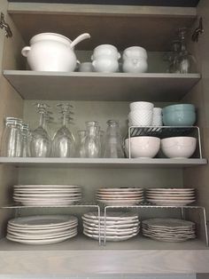 the shelves are filled with dishes and glasses