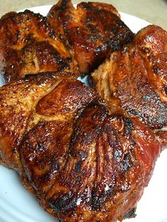 four pieces of meat sitting on top of a white plate