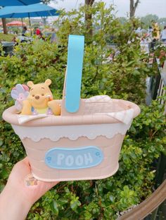 someone holding up a toy bathtub with a winnie the pooh figure in it