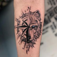 a black and white photo of a lion with compass on it's arm, done by abhiki zone tattoo