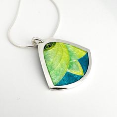 "This item is in stock and ready to ship! Seafoam Green & Blue Lotus Flower Pendant - Cloisonné & Champlevé Vitreous Glass Enamel on Fine Silver with Sterling Silver Chain by Sandra McEwen Materials: Champlevé & cloisonné Enamels on Fine silver. Pendant Size: 1.25' x 1.25\" Includes an 18\" Sterling Silver chain ------------------------------------------------------------------------------------------------ Did you know that enamels are melted glass?   Yes!  It's true...  To create this lovely p Green Teardrop Necklace, Unique Green Necklaces For Weddings, Unique Green Necklace For Wedding, Green Lotus Flower, Lotus Flower Pendant, Blue Lotus Flower, Blue Lotus, Cloisonne Enamel, Enamels