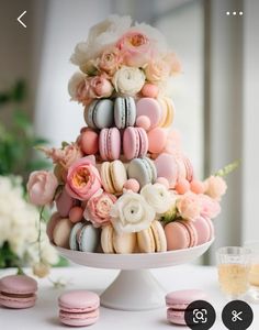 macaroons and flowers are arranged on a cake stand