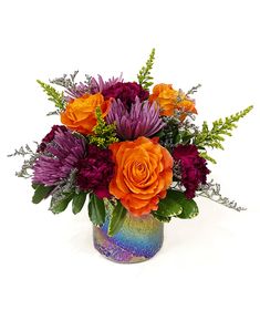 a vase filled with lots of different colored flowers