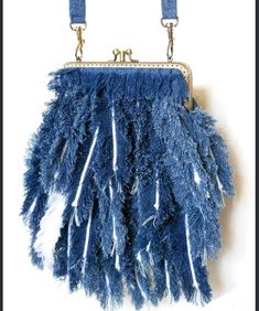 a blue purse with fringes hanging from it