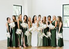 a group of women standing next to each other in front of a window holding bouquets