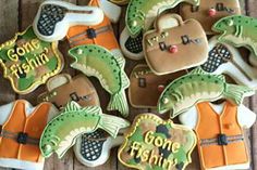 decorated cookies are arranged on a table for someone's fishing themed birthday cake topper