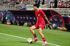 a soccer player is about to kick the ball in front of an onlooker