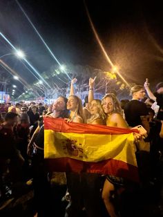 some people are standing together holding a flag