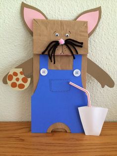 a paper bag with a cat holding a drink